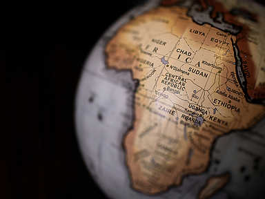 Nahaufnahme eines Globus mit Fokus auf den afrikanischen Kontinent. Sichtbar sind Länder wie Sudan, Tschad, Libyen, Ägypten, Zentralafrikanische Republik, Uganda und Äthiopien. Sudan liegt zentral im Bild. Nahaufnahme eines Globus mit Fokus auf den afrikanischen Kontinent. Deutlich sichtbar sind die Länder Sudan, Tschad, Libyen, Ägypten, Zentralafrikanische Republik, Uganda und Äthiopien. Die Beschriftungen sind in englischer Sprache, die Region Sudan liegt zentral im Bild.