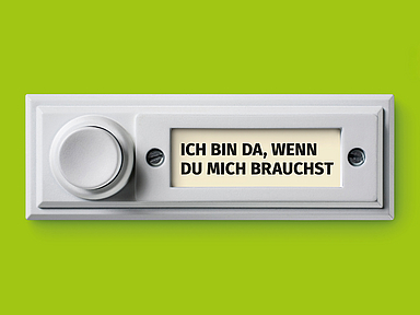 Weiße Türklingel auf grünem Hintergrund. Auf dem Namensschild steht in schwarzer Schrift: „ICH BIN DA, WENN DU MICH BRAUCHST“. Das Motiv ist schlicht und klar gestaltet. Das Bild zeigt eine weiße Türklingel vor grünem Hintergrund. Auf dem Namensschild der Klingel steht in Großbuchstaben: «ICH BIN DA, WENN DU MICH BRAUCHST».