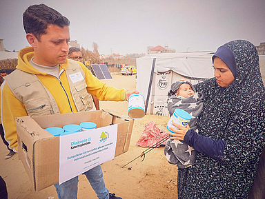 Ein Mitarbeiter der Hilfsorganisation verteilt Dosenmilch für Neugeborene und Kleinkinder in einem Flüchtlingscamp in Rafah im südlichen Gazastreifen. Ein Mitarbeiter der Hilfsorganisation verteilt Dosenmilch für Neugeborene und Kleinkinder in einem Flüchtlingscamp in Rafah im südlichen Gazastreifen.