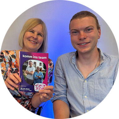 Die Wahlbeauftragte Pfarrerin Ulrike Joachimi und Kirchenvorsteher Johannes Ickler lächeln mit einem Plakat der Kampagne 2025 in die Kamera. Die Wahlbeauftragte Pfarrerin Ulrike Joachimi und Kirchenvorsteher Johannes Ickler lächeln mit einem Plakat der Kampagne 2025 in die Kamera.