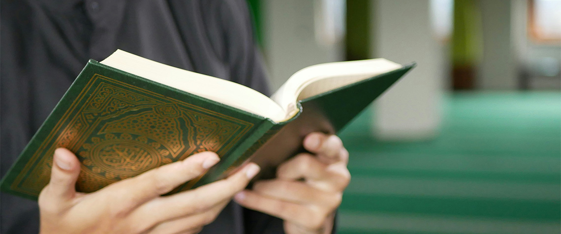 Unser Foto zeigt einen Beter mit dem Koran, der Heiligen Schrift des Islams. (Foto: Unsplash)