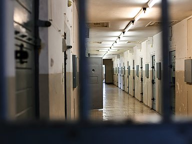 Blick auf Türen in einen Gefängnis-Korridor.