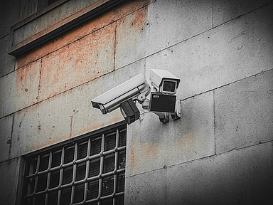 Unser Symbolbild zeigt Überwachungskameras an einer Gebäudewand. Menschlicher Freiraum ist in modernen Justizvollzugsanstalten kaum zu finden. Kameras und lückenlose Überwachung lassen kaum Raum für Privatsphäre. Unser Symbolbild zeigt Überwachungskameras an einer Gebäudewand.