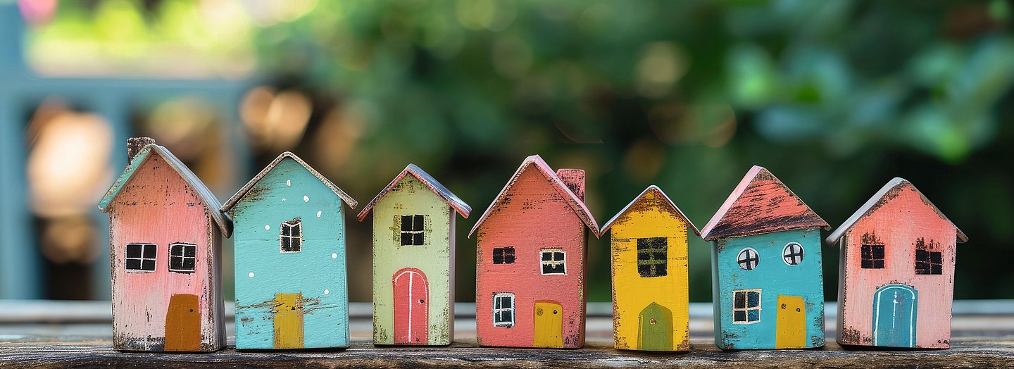 Modell bunt angemalter Häuser auf einem Holztisch