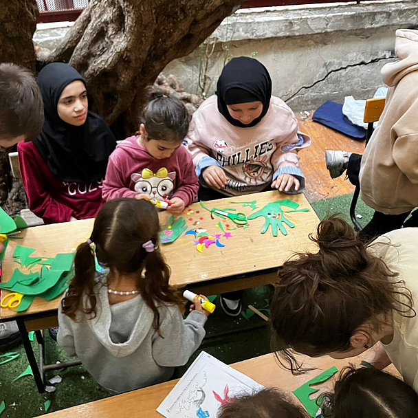Fünfzehn Studierende sowie mehrere Mitarbeitende und Lehrende der NEST bieten ein- bis zweimal pro Woche Bildungs- und Freizeitprogramme für die geflüchteten Kinder und Jugendlichen an – darunter Bastelangebote und Bewegungsspiele. Das Bild zeigt Kinder beim basteln.
