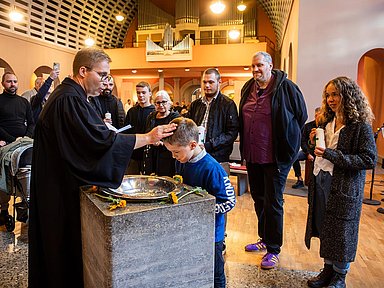 Unser Foto zeigt Pfarrer Ralf Haunert mit der Familie Klemm aus Kassel bei der Taufe von Vincent in der Friedenskirche.