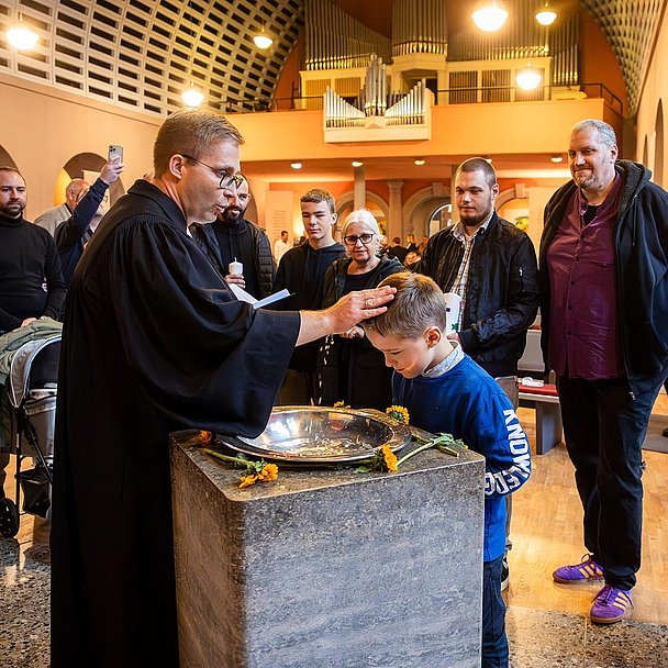 Unser Foto zeigt Pfarrer Ralf Haunert mit der Familie Klemm aus Kassel bei der Taufe von Vincent in der Friedenskirche.