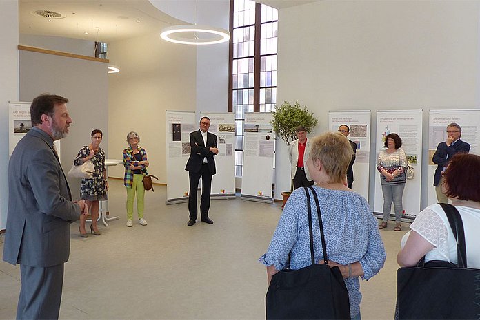 Dekan Dr. Martin Lückhoff (Evangelischer Kirchenkreis Hanau, vorne links) begrüßt die Gäste bei der Ausstellungseröffnung. (Foto: medio.tv/Heller)