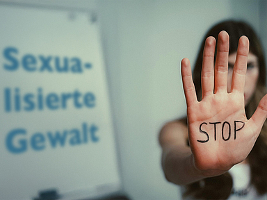 Eine Frau zeigt ihre Hand, auf der Stop geschrieben ist. Daneben steht der Schriftzug "Sexualisierte Gewalt". Eine Frau zeigt ihre Hand, auf der Stop geschrieben ist. Daneben steht der Schriftzug "Sexualisierte Gewalt".