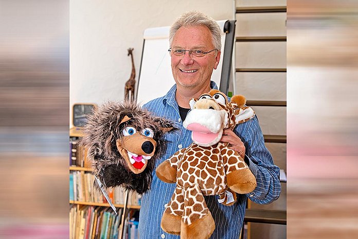 Der Diplom-Pädagoge Magnus von Kortzfleisch mit dem Wolf und der Giraffe in seinem Dienstzimmer in Jesberg. (Foto: medio.tv/Dellit)