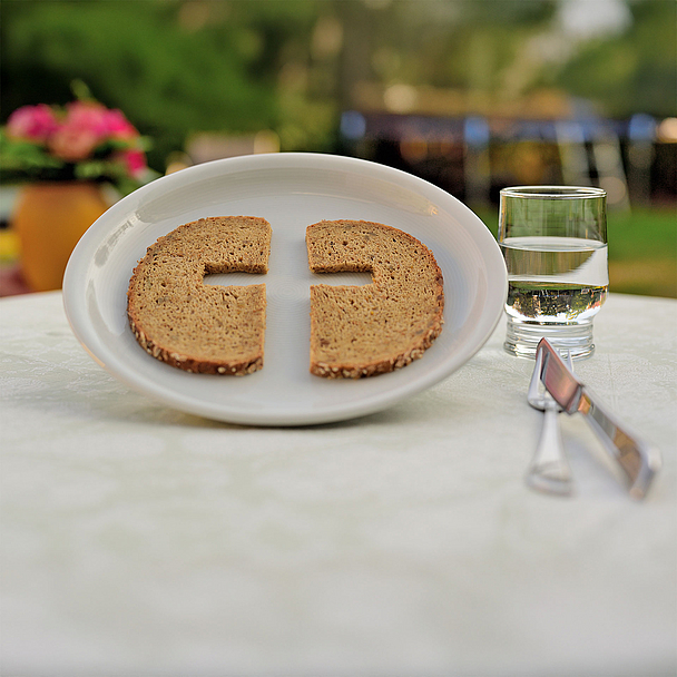 Unser Foto zeigt ein Symbolbild zur Fastenzeit mit Teller, Brot und Wasser