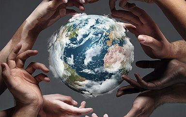 Hands holding planet Earth, close up on grey background. Environment save, taking care of nature and ecology, supporting hands concept