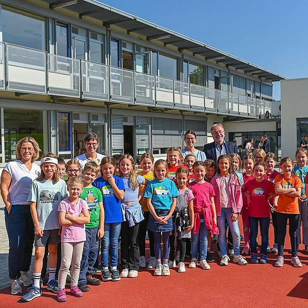 Schülerinnen und Schüler der Katharina-von Bora-Schule mit der Schulleitung und weiteren Gästen vor der neuen Mensa (hinten rechts)