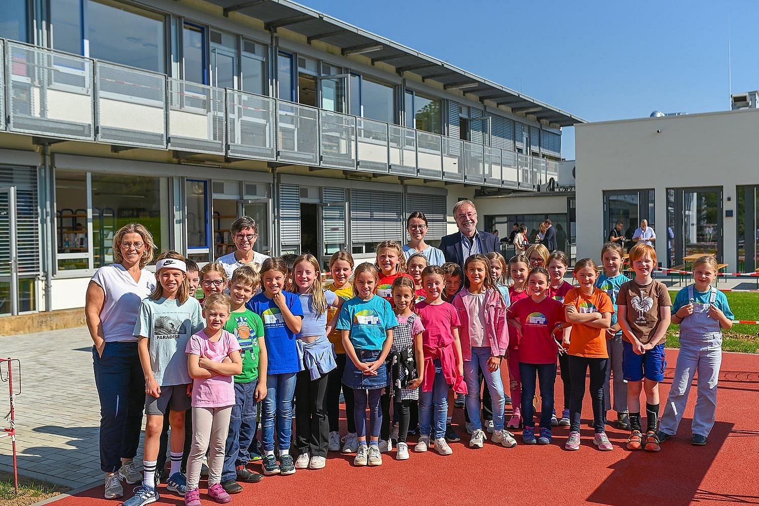 Schülerinnen und Schüler der Katharina-von Bora-Schule mit der Schulleitung und weiteren Gästen vor der neuen Mensa (hinten rechts)