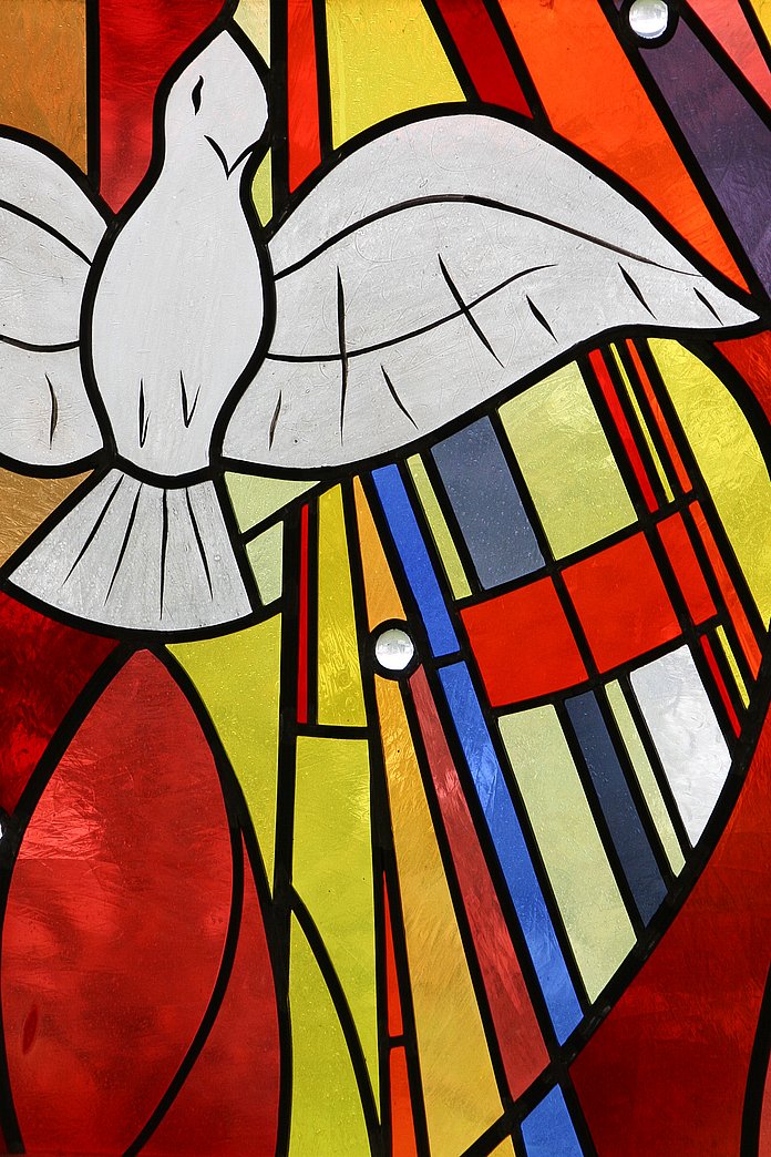 Kirchenfenster mit der Darstellung einer Friedenstaube. Die Fenstergestaltung ist von Heide und Jürgen Müller aus dem Jahr 1992 - Evangelische Kirche Heiligenrode