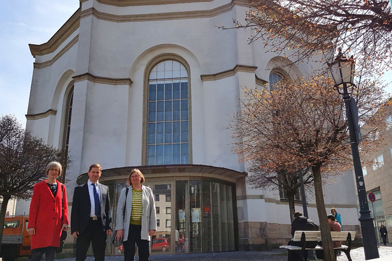 (v. l. n. r.)Pröpstin Katrin Wienold-Hocke, Dekan Dr. Michael Glöckner und Pfarrerin Gabriele Heppe-Knoche stehen vor der Karlskirche. Sie gehören zum Projektteam von «drei in eins. kunst –  musik – sprache».