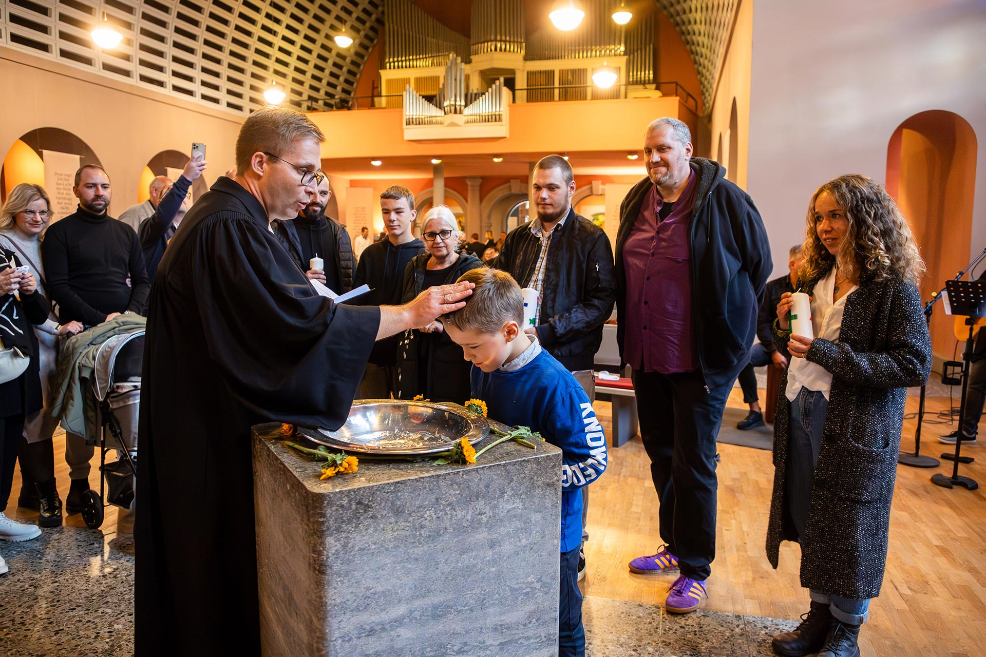 Unser Foto zeigt Pfarrer Ralf Haunert mit der Familie Klemm aus Kassel bei der Taufe von Vincent in der Friedenskirche.